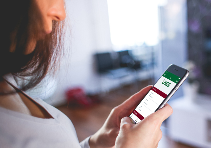 Woman holding a smartphone displaying the U-Log app